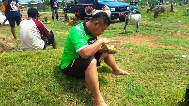 Anggota Tim Pemakaman Makan Pagi Nasi Bungkus di Tengah Area Kuburan