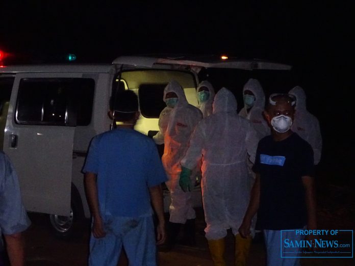 Tim Pemakaman Badan Penanggulangan Bencana Daerah (BPBD) Pati 1 bersama personel pengantar dari Rumah Sakit (RS) Fastabiq Sehat Pati saat menurunkan jenazah dari ambulans dan mengusungya ke lubang pemakaman.