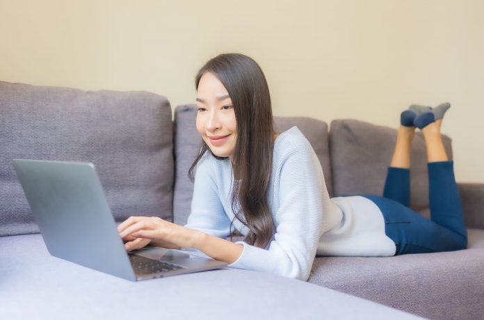 Portrait beautiful young asian woman use laptop for working in living room