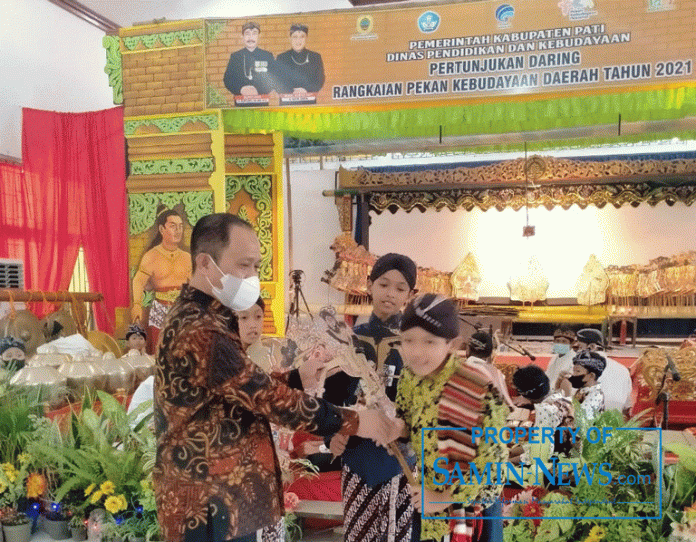Ketua Pepadi Kabupaten Pati, Farid Suhanto MPd secara simbolis menyerahkan wayang kepada dua dalang cilik sebagai penampil pertama dan kedua dalam Lomba Dalang Anak dan Remaja hari kedua, di Sanggar Kegiatan Belajar (SKB), Jumat (22/Oktober) hari ini.(Foto:SN/dok-ed)