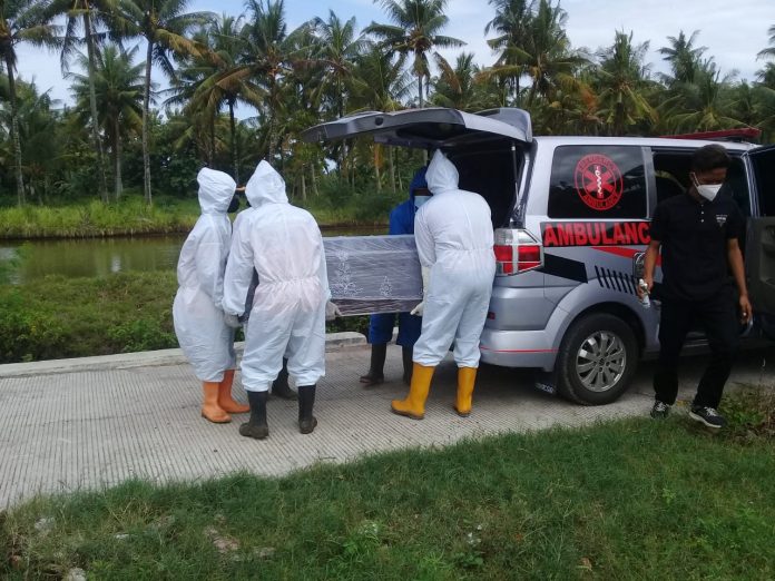 Tim Relawan Pemakaman Jenazah Tunggul Wulung saat menurunkan peti jenazah dari ambulans pengangkut, untuk dimakamkan dengan standar protokol Covid-19, di Desa Banyutowo, Kecamatan Dukuhseti.(Foto:SN/dok-tw)