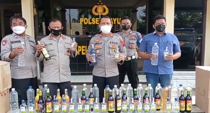 Kapolsek Tayu Iptu Aris Pristianto SH MH bersama personel jajaran dan barang bukti berbagai jenis minuman keras (miras) yang disita dari tangan para penjualnya.