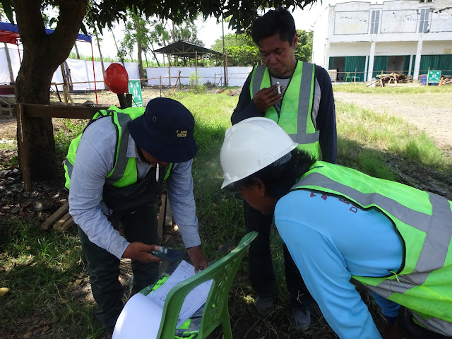 Papan kegiatan pelaksanaan pekerjaan pembangunan Rumah Potong Hewan (RPH) di lingkungan Pasar Hewan Margorejo, di pinggir jalan raya Pati-Kudus KM 4,5 (atas) dan pelaksana lapangan rekanan CV Hokage Pati tengah memberikan arahan kepada ketua kelompok pekerja (bawah)