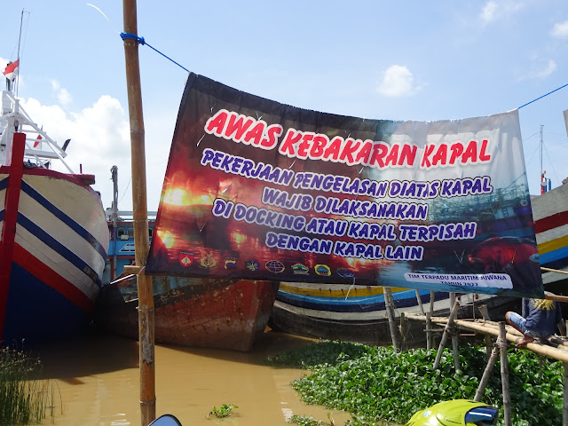 Spanduk peringatan dini adanya ancaman kebakaran kapal penangkap ikan yang saat menjelang dan sesudah Lebaran banyak yang sandar di tepi alur Kali Juwana.(Foto:SN/aed)