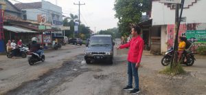 Aktivis GMNI Jepara, Yoga Bactiar (kanan/merah) menunjukkan ruas jalan Jepara-Bangsri yang rusak