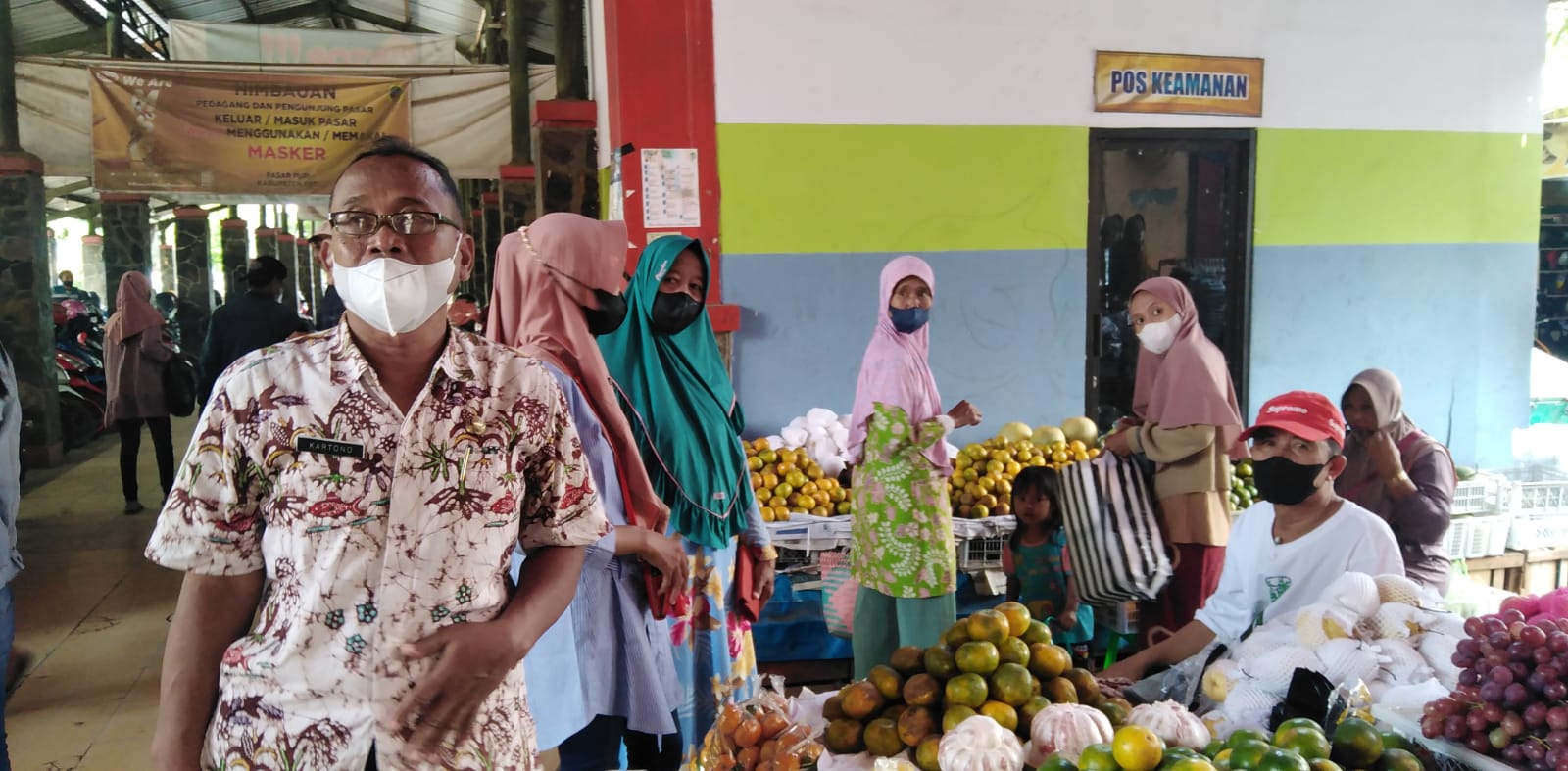 Kepala Pasar Puri Baru (kiri), Kartono sedang berkeliling pasar mengingatkan para pedagang terkait menjaga keamanan ketertiban dan menjaga prokes