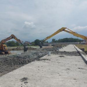 Salah satu ekskavator ''lengan panjang'' lainnya, tetap bertugas di lokasi pembuangan untuk mendorong tanah galian, agar masuk ke dalam lubang pembuangan yang harus diuruk.(Foto:SN/dok-liq)