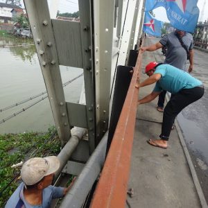 Personel dari PDAM Tirta Bening Pati saat melalukan pembongkaran jaringan pipa yang terpasang di sela-sela konstruksi sisi kanan (selatan) Jembatan Juwana I atau jembatan lama yang Minggu (22/Mei) 2022 bagian sebelah barat ikut terbakar.(Foto:SN/aed)