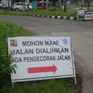 Persediaan material beskose sudah ada di lokasi segmen I untuk paket pekerjaan rigid beton tapi belum bisa dilaksanakan (atas) dan pemberitahuan untuk pengalihan jalan karena ada pengecoran ini lebih baik disinggkirkan dulu.(bawah).(Foto:SN/aed)