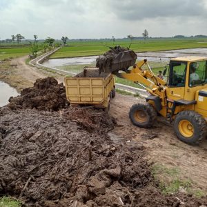 Ekskavator loader saat menaikkan sampah bercampur lumpur ke atas ''dump truck.'' (Foto:SN/aed)