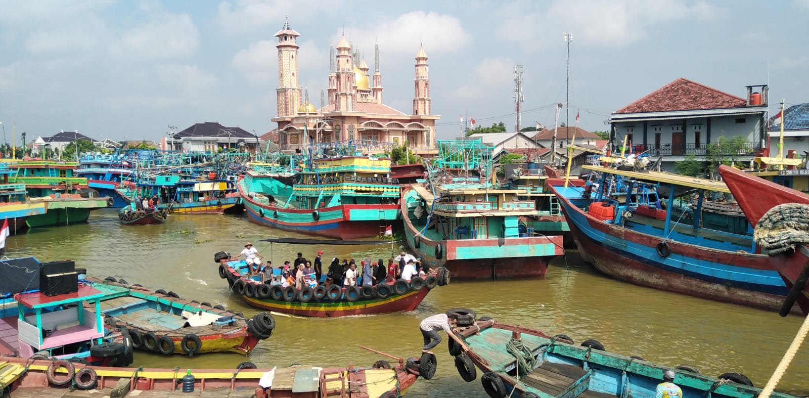 Sejumlah orang naik perahu untuk syukuran di laut