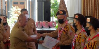 Pj Bupati Pati, Henggar Budi Anggoro saat menyerahkan piagam penghargaan kepada kontingen pramuka Kwarcab Pati yang sebelumnya mengikuti Jamnas