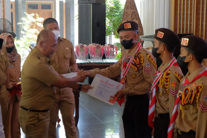 Pj Bupati Pati, Henggar Budi Anggoro saat menyerahkan piagam penghargaan kepada kontingen pramuka Kwarcab Pati yang sebelumnya mengikuti Jamnas