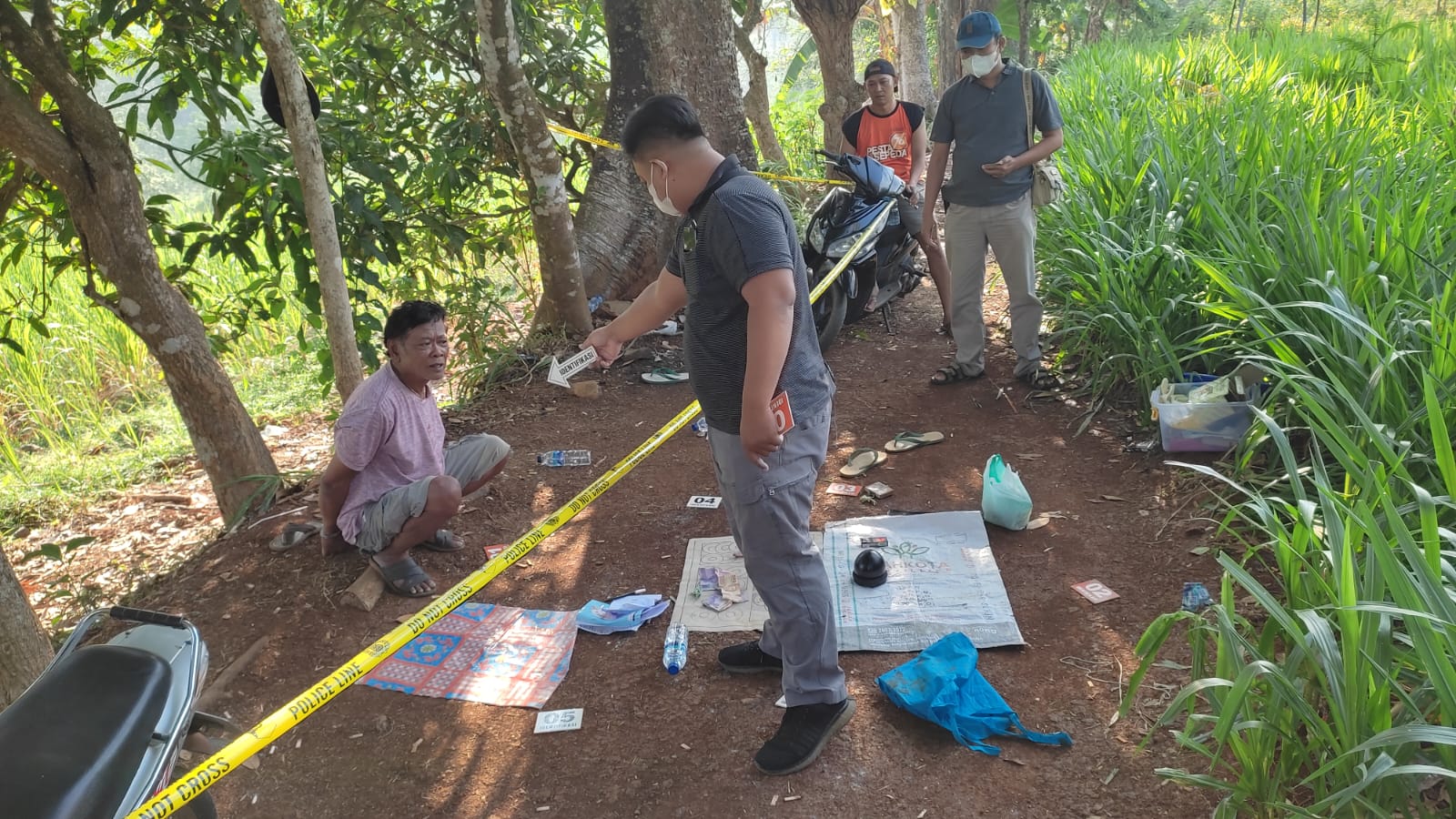 Kepolisian saat menggerebek kebun singkong yang dijadikan tempat dadu