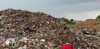 Tampak seseorang tengah mencari rosokan di tengah gunungan timbunan sampah di TPA Sukoharjo