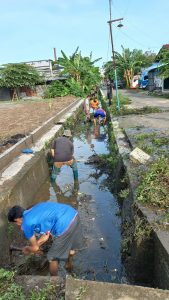 Tampak beberapa masyarakat sedang membersihkan saluran air