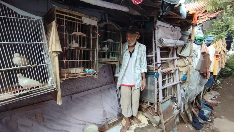 Kusrin tampak sedang memberi makan burung