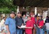 Simbolis, Kades Ngemplak Kidul (baju hitam) Slamet menyerahkan bantuan bagi korban banjir bandang yang diterima Kades Godo (baju merah) Suwondo