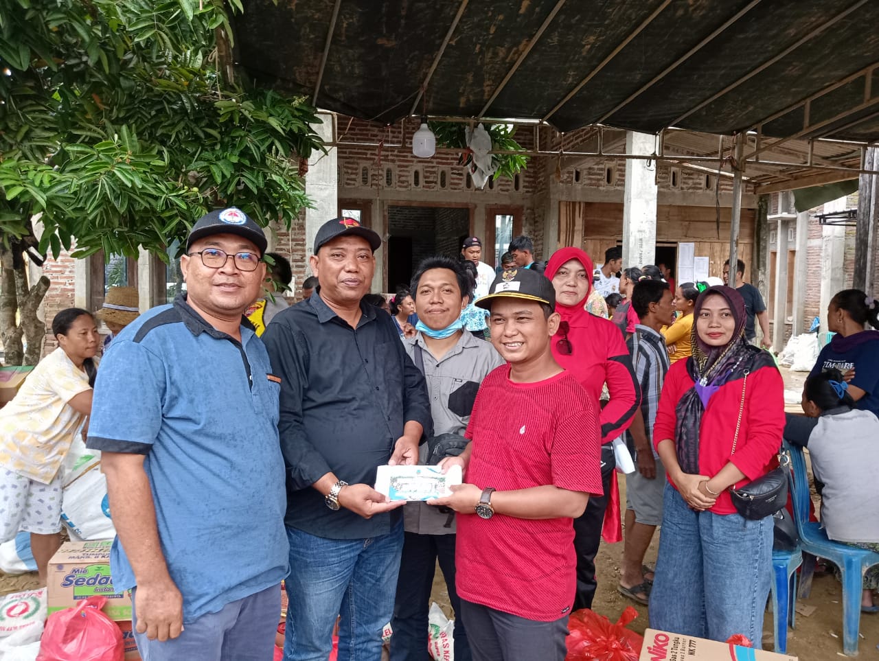 Simbolis, Kades Ngemplak Kidul (baju hitam) Slamet menyerahkan bantuan bagi korban banjir bandang yang diterima Kades Godo (baju merah) Suwondo