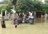 Tampak anak kecil melintas di tengah banjir