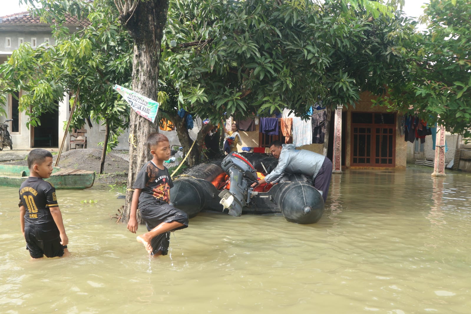 Tampak anak kecil melintas di tengah banjir