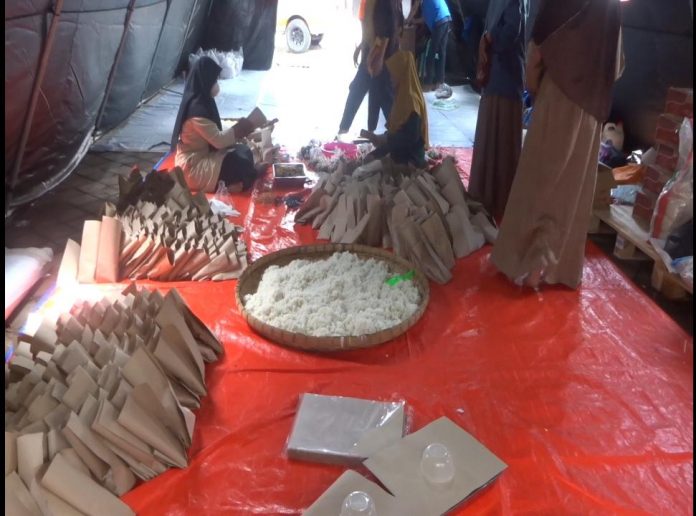 Tampak ibu-ibu relawan sedang mempersiapkan nasi bungkus bagi warga terdampak banjir Tampak ibu-ibu relawan sedang mempersiapkan nasi bungkus bagi warga terdampak banjir