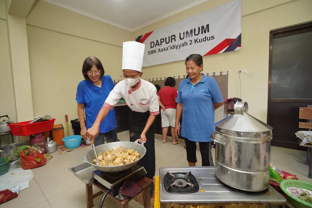 Foto: tampak kedua siswa-siswi SMK Assa'idiyyah 2 Kudus sedang fokus memasak untuk warga terdampak banjir