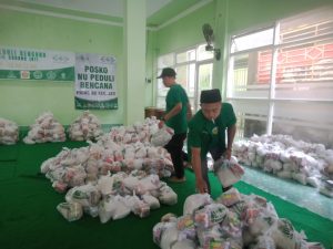 Tampak beberapa organ NU sedang menata paket sembako yang akan dihantarkan untuk warga yang terkena dampak banjir