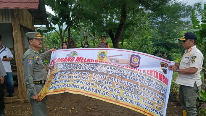 Petugas gabungan memasang spanduk melarang aktivitas penambangan ilegal di Desa Ngablak, Kecamatan Cluwak Kabupaten Pati