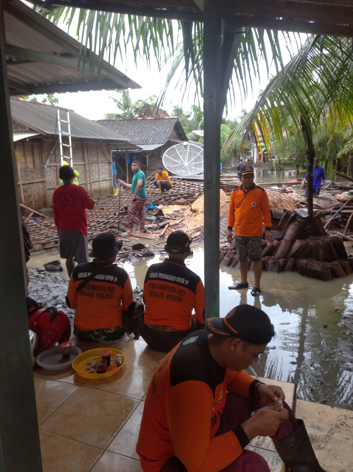 Relawan SAR Tunggul Wulung bersama warga membantu membersihkan material rumah roboh milik Rebinah