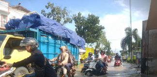 Foto: Tampak pengendara motor sedang berjuang melewati jalan banjir