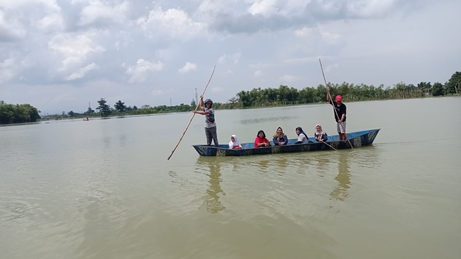 Petugas menaiki perahu untuk membagikan bantuan makanan siap saji (Samin News /istimewa)