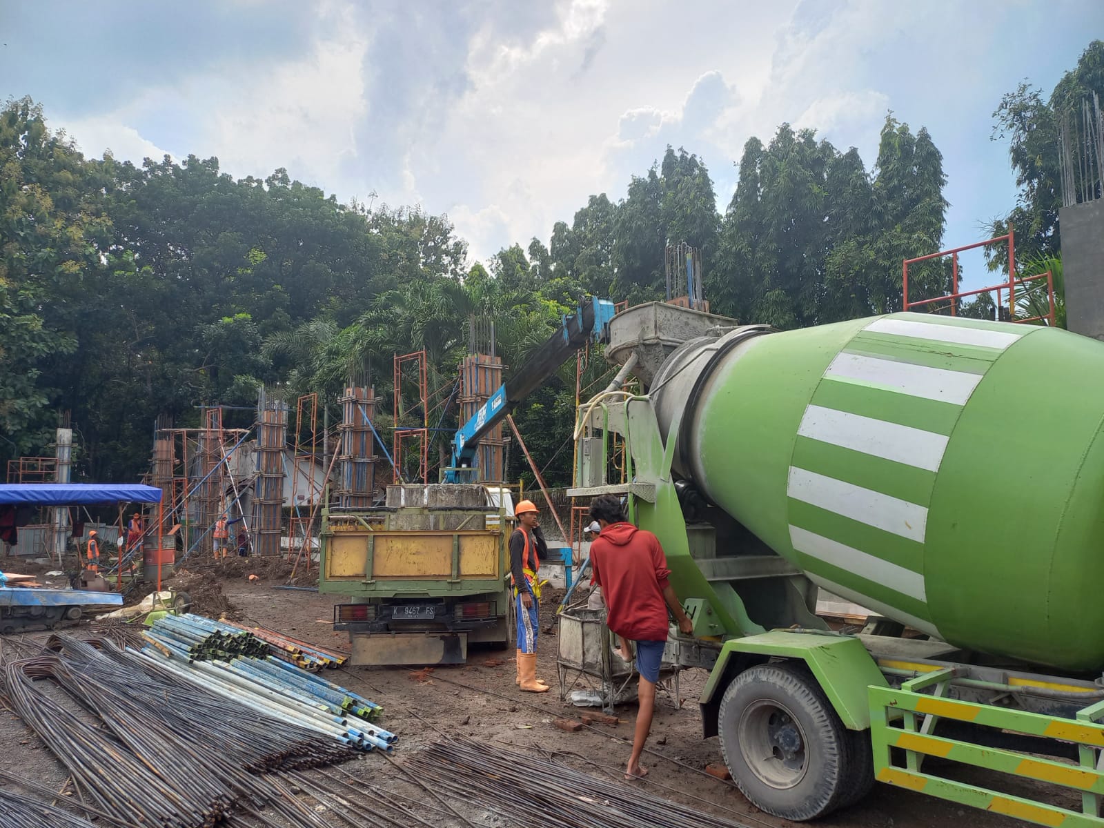 Tampak pekerja tengah mengerjakan pengecoran tiang struktur konstruksi gedung senam