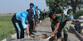 Foto: Tampak anak-anak Pramuka yang berasal dari SMA Negeri 1 Mejobo sedang membantu anggota kegiatan TNI