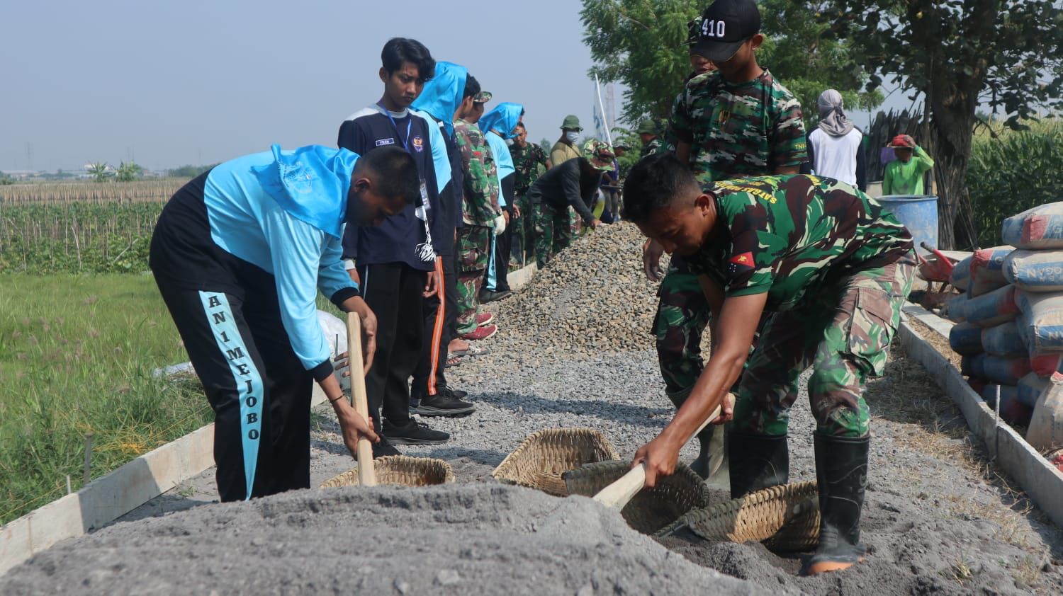 Foto: Tampak anak-anak Pramuka yang berasal dari SMA Negeri 1 Mejobo sedang membantu anggota kegiatan TNI