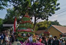 Gunungan hasil bumi yang dihias diarak saat karnaval di Desa Pakis