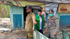 Petugas Satpol PP menunjukkan kondom bekas di lokasi pembongkaran warung Margorejo