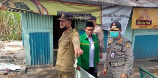 Petugas Satpol PP menunjukkan kondom bekas di lokasi pembongkaran warung Margorejo