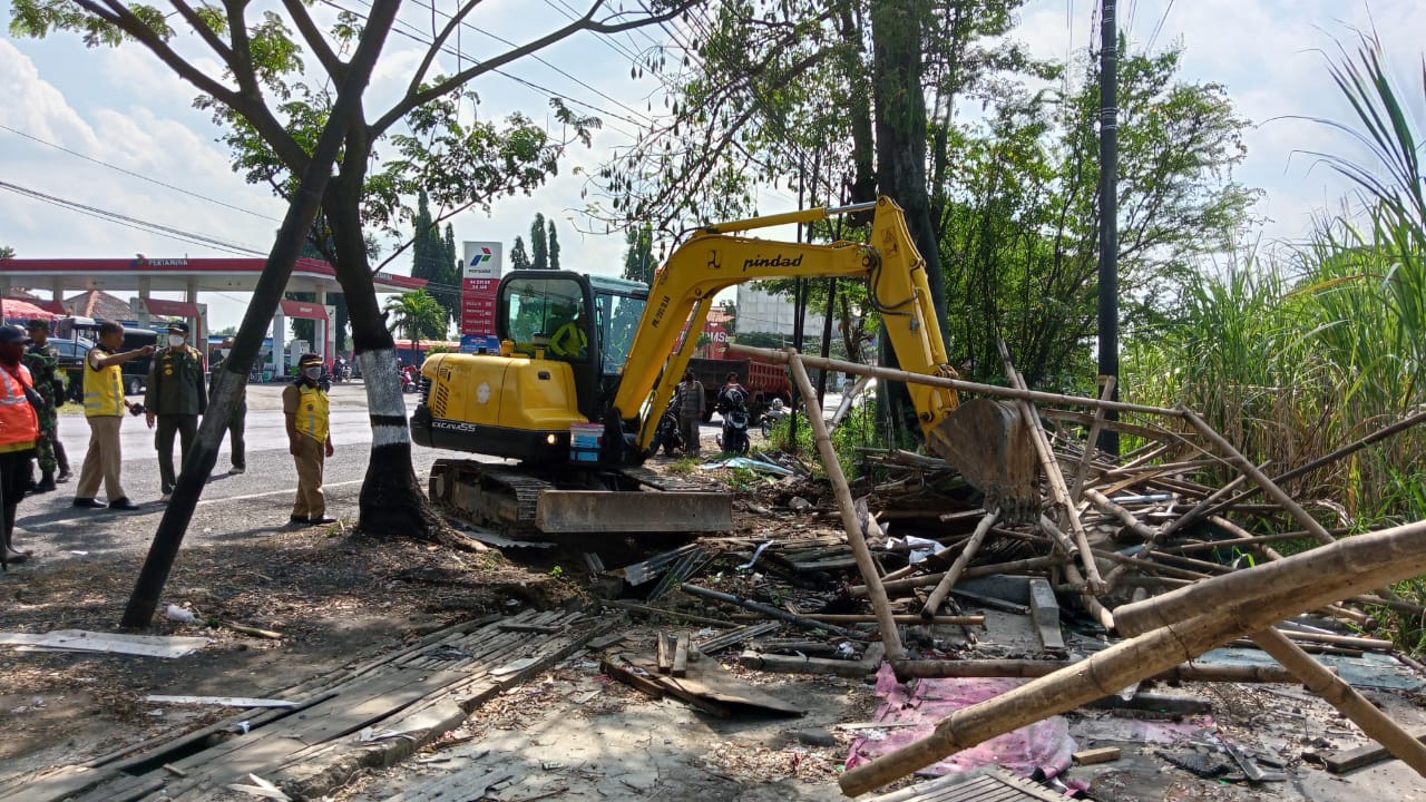 Alat berat diturunkan untuk membongkar puluhan warung prostitusi di Margorejo, Senin (12/6/2023)