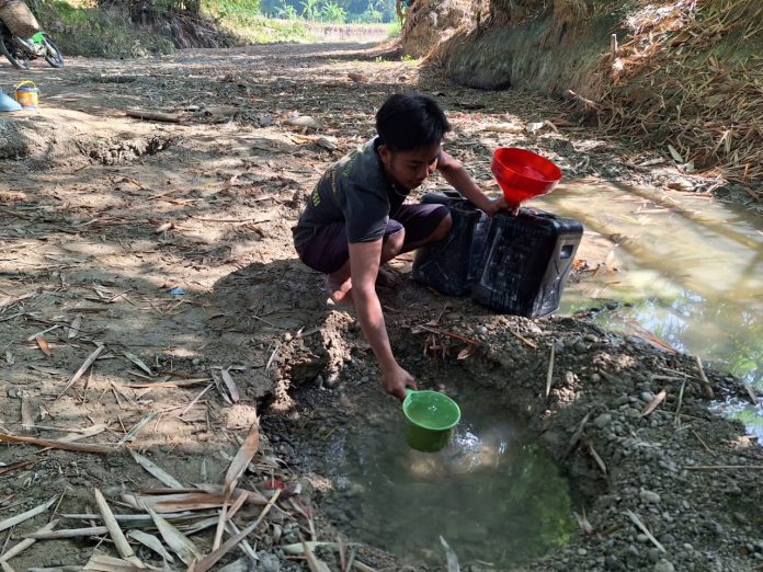 Warga mengambil air dari sumur di sungai atau belik Warga mengambil air dari sumur di sungai atau belik