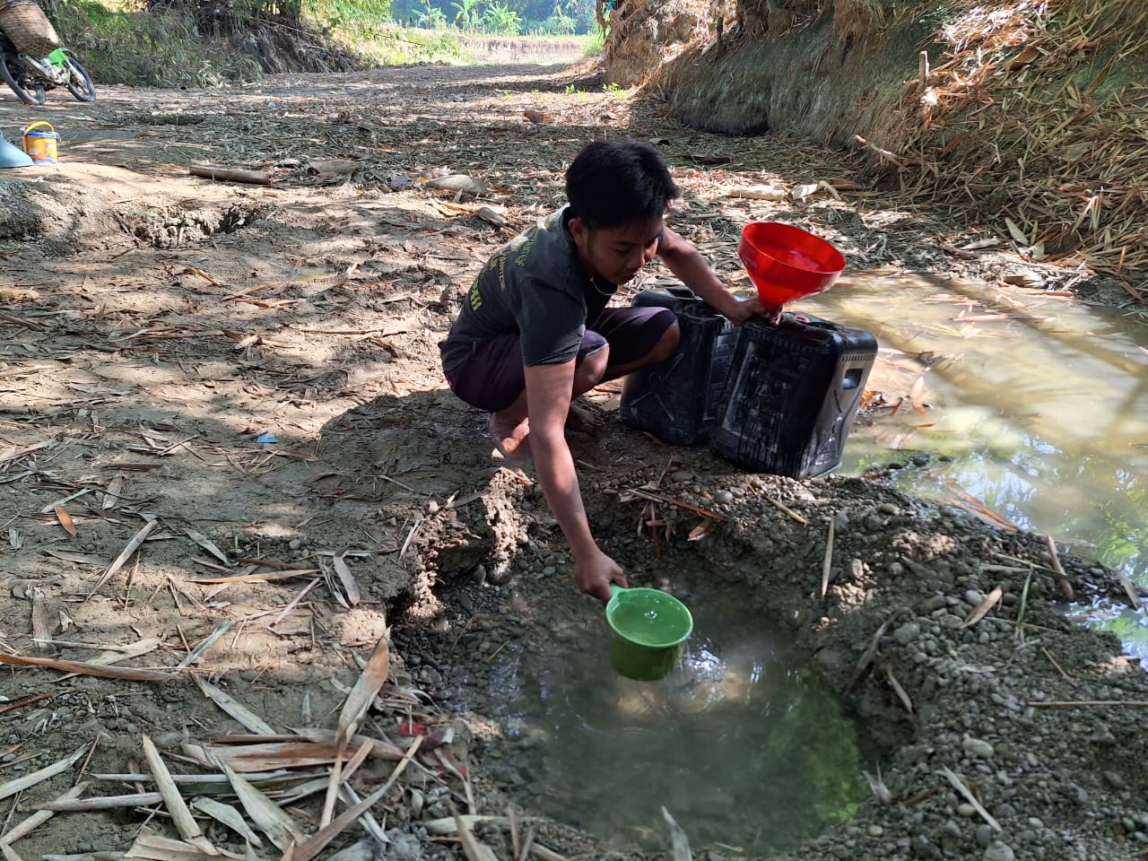 Warga mengambil air dari sumur di sungai atau belik