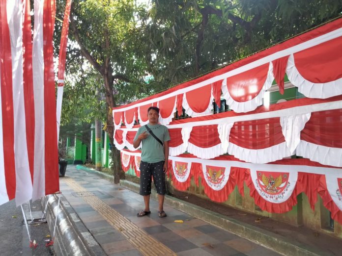 Ono warga Sumedang Jawa Barat berjualan bendera menjelang HUT kemerdekaan Republik Indonesia di Kabupaten Pati