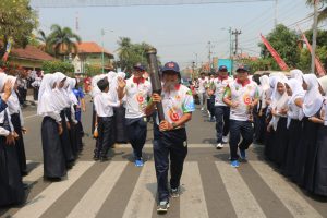 Salim atlet gulat nasional asal jepara membawa obor.